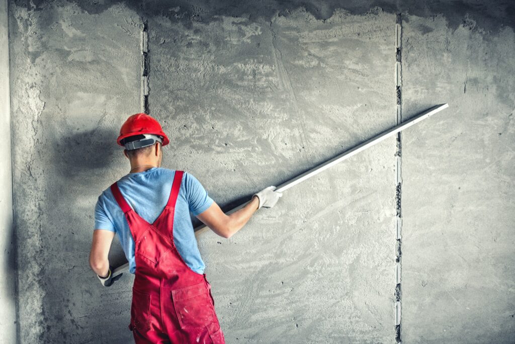 industrial worker with plastering tools renovating a house. builder worker plastering facade